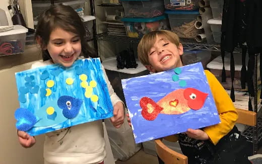 a couple of children holding a painting