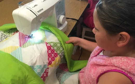 a baby looking at a sewing machine