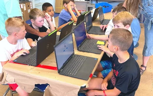 a group of kids using laptops