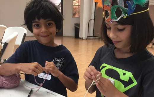 a couple of kids sitting at a table with a paper and a paper