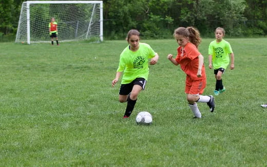 a group of kids compete over a football ball