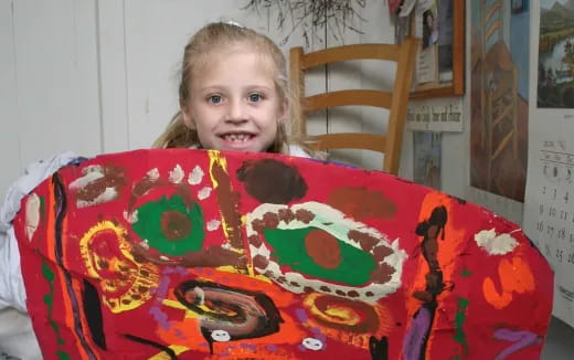 a girl sitting at a table with a cake on it