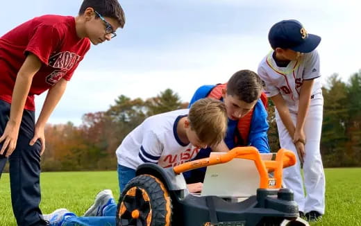 a group of people working on a lawn mower