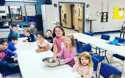 a group of children sitting at a table