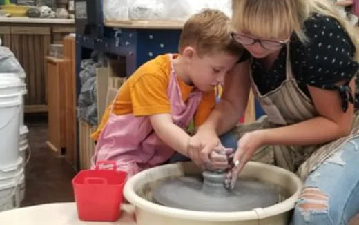 a person and a child washing dishes