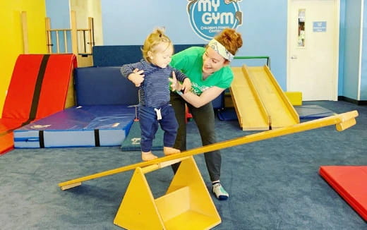 a person and a child playing on a playground toy