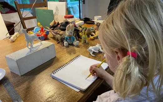 a girl drawing on a paper