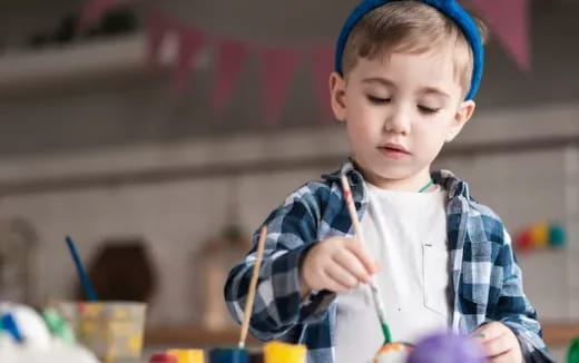 a young boy holding a pencil