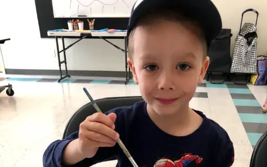 a boy holding a pencil