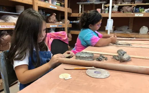 a few young girls playing with clay