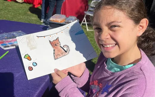 a girl holding a drawing