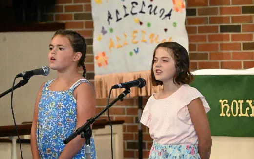 a couple of girls standing in front of a microphone