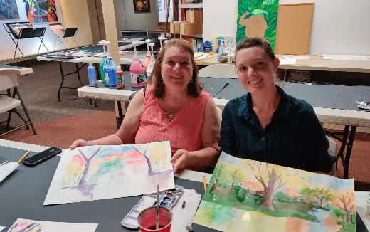 a couple of women sitting at a table with a map