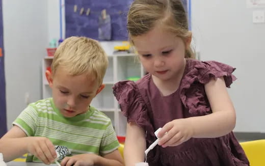 a couple of children sitting at a table