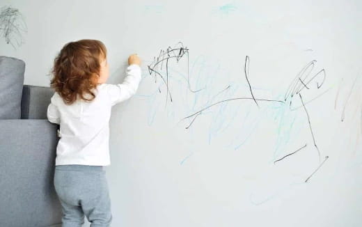 a child drawing on a white board