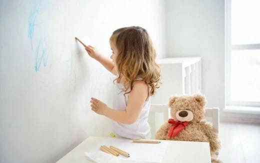 a little girl writing on a whiteboard