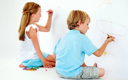 a young boy and girl drawing