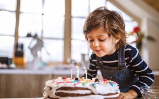 a child blowing out candles on a cake