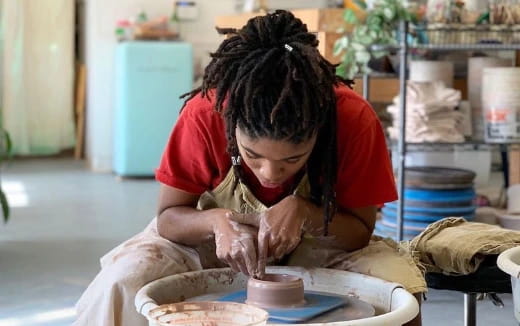 a person making a clay pot