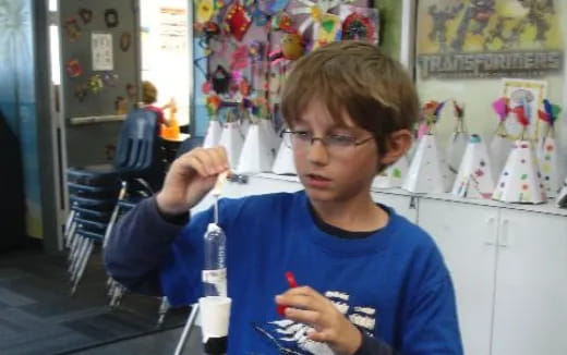 a boy holding a plastic bottle