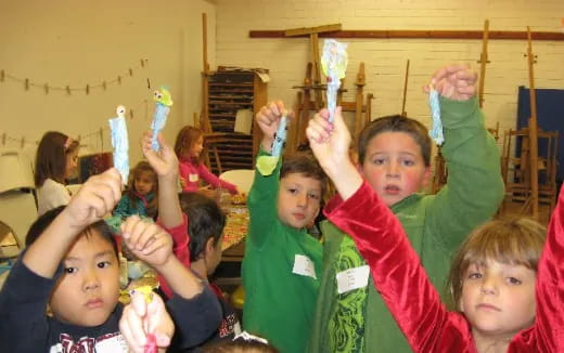 a group of children raising their hands