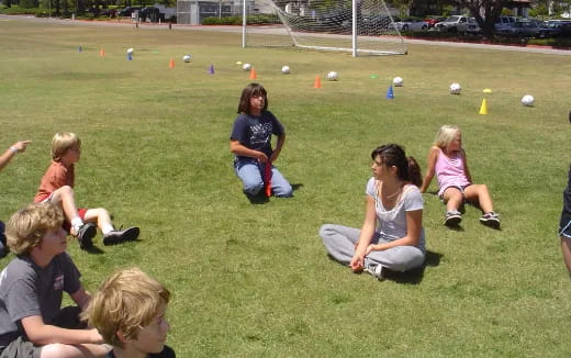 a group of people sitting on the grass