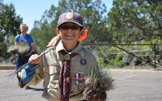 a boy holding a bundle of grass