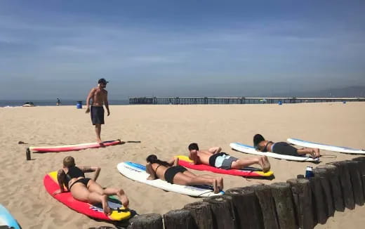 a group of surfers laying on the beach