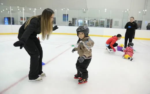 a person and a child on an ice rink