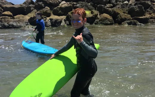 a boy holding a surfboard