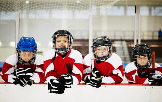 a group of people wearing helmets and holding hockey sticks