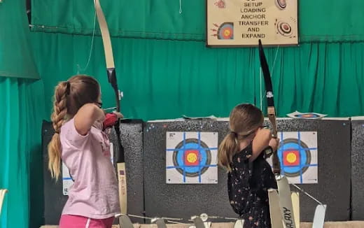 a few girls practicing archery