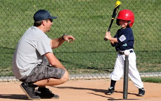 a person and a boy playing baseball