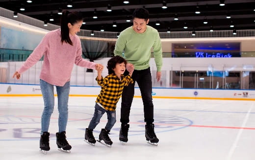 a man and woman and a child ice skating