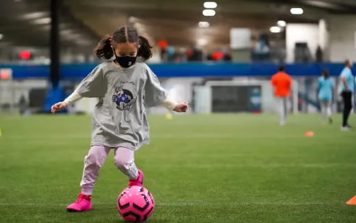a little girl playing football