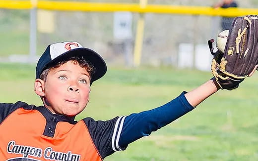 a boy catching a baseball