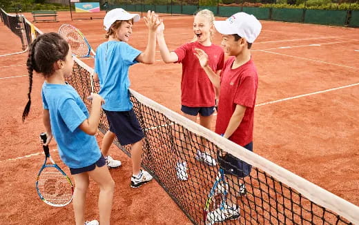 a group of kids playing tennis