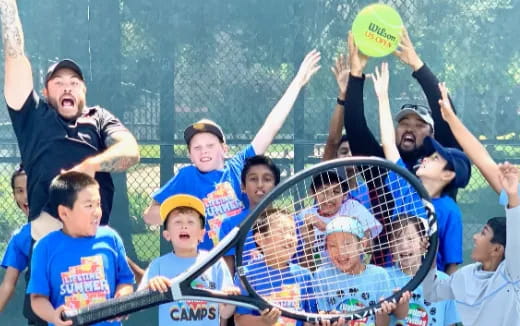 a group of kids playing ping pong