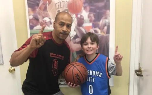 a person and a boy holding basketballs