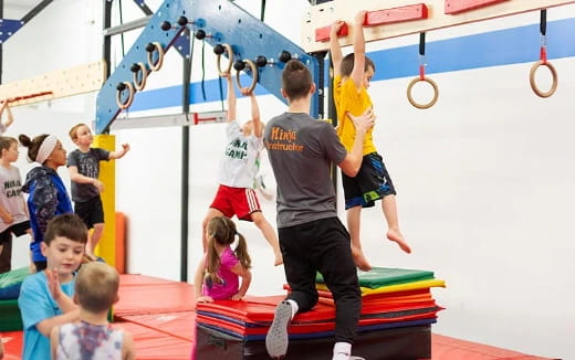 a group of kids playing on a gym mat