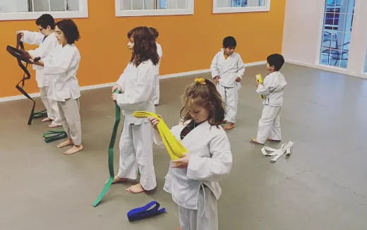 a group of children in white karate uniforms