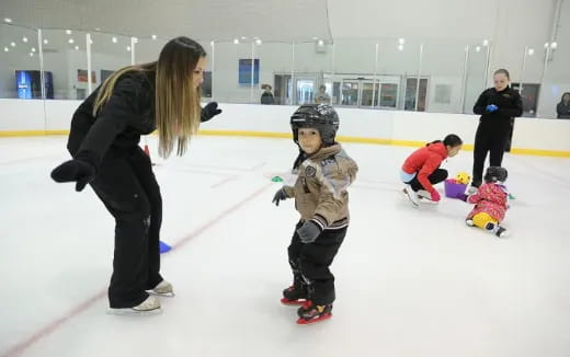 a person and a child on an ice rink