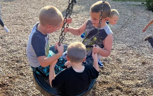 a group of kids playing on a swing set