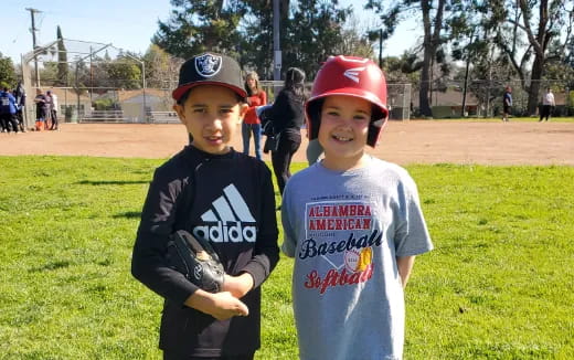 a couple of kids in baseball uniforms