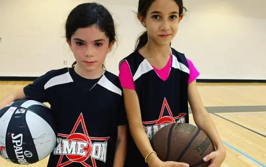 a couple of girls holding basketballs