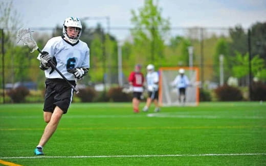 a person wearing a helmet and holding a stick on a field