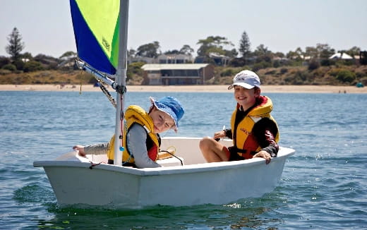 a couple of kids in a small boat on the water