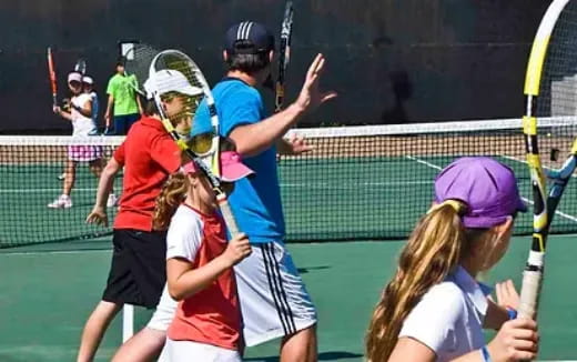 a group of people playing tennis