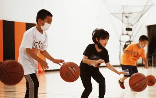 a group of kids playing basketball