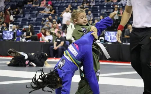 a person in a blue uniform holding another man in a blue uniform